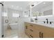 Luxurious bathroom featuring dual sinks, modern fixtures, and glass-enclosed shower with a soaking tub at 1514 55Th N Ave, St Petersburg, FL 33703