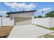 Attached two-car garage with a concrete driveway surrounded by a white privacy fence at 1514 55Th N Ave, St Petersburg, FL 33703