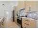 Modern kitchen with stainless steel appliances, light wood cabinetry, and marble backsplash at 1514 55Th N Ave, St Petersburg, FL 33703