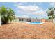Back yard featuring an in ground pool surrounded by wood mulch and a wood privacy fence at 1758 Southview Rd, Largo, FL 33770