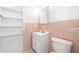 Bright bathroom with white fixtures, pink tile accent and built in shelves for ample storage at 1758 Southview Rd, Largo, FL 33770