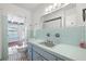 Vintage bathroom with tiled counter, blue tile walls and a view into a tiled sun room with pool access at 1758 Southview Rd, Largo, FL 33770