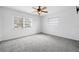 Bright bedroom featuring new carpet, ceiling fan, and ample natural light from two windows at 1758 Southview Rd, Largo, FL 33770