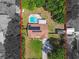 An aerial view of a home with a backyard pool, solar panels, and green lawn at 17605 Simmons Rd, Lutz, FL 33548