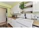 Modern kitchen with a farmhouse sink, open shelving, and tile backsplash at 17605 Simmons Rd, Lutz, FL 33548
