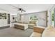 Cozy living room features plush seating, a ceiling fan, and a large window overlooking the front yard at 17605 Simmons Rd, Lutz, FL 33548