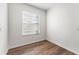A minimalist bedroom with wood floor, white walls, and a sun-filled window at 20146 Heritage Point Dr, Tampa, FL 33647