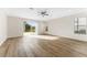 Open living room with wood floors and sliding glass doors offering view of the serene backyard at 20146 Heritage Point Dr, Tampa, FL 33647