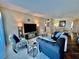 Cozy living room featuring plush seating, a large television, and an adjoining dining area at 2469 Franciscan Dr # 53, Clearwater, FL 33763