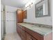 Bathroom featuring a double sink vanity with green marble countertop and wood cabinets at 2540 S Shore Se Dr, St Petersburg, FL 33705