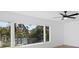 Bedroom view featuring a ceiling fan and large windows overlooking lush tropical scenery at 2540 S Shore Se Dr, St Petersburg, FL 33705
