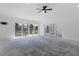 Open living room features stylish ceiling fan, concrete floors, and multiple sliding glass doors at 2540 S Shore Se Dr, St Petersburg, FL 33705