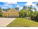 Inviting single-story home featuring a three-car garage and lush tropical landscaping at 2613 Bonterra Blvd, Valrico, FL 33594