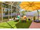 Enclosed patio featuring chairs, table and artificial grass at 2613 Bonterra Blvd, Valrico, FL 33594