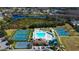 Aerial view of community amenities featuring pool, tennis courts, basketball courts, and lake views in a residential neighborhood at 3009 Sheehan Dr, Land O Lakes, FL 34638