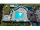 Aerial view of a community pool area with a lap pool, lounge chairs, and a covered seating area at 3009 Sheehan Dr, Land O Lakes, FL 34638