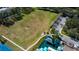 Aerial view of a playground, basketball court, and recreational field with trees and walking paths at 3009 Sheehan Dr, Land O Lakes, FL 34638