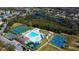 Aerial view of community amenities with pool, tennis, basketball courts, lake, and playground in residential neighborhood at 3009 Sheehan Dr, Land O Lakes, FL 34638