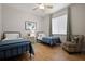 Bright bedroom with two beds, wood floors, and a ceiling fan with natural light at 3009 Sheehan Dr, Land O Lakes, FL 34638
