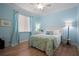 Cozy bedroom features blue walls, a ceiling fan, and a bright window with curtains at 3009 Sheehan Dr, Land O Lakes, FL 34638