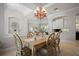 Elegant dining room featuring a decorative chandelier, arched window, and an open-concept design at 3009 Sheehan Dr, Land O Lakes, FL 34638