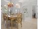 Elegant dining room featuring a decorative chandelier, arched window, and travertine floors at 3009 Sheehan Dr, Land O Lakes, FL 34638