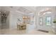 Formal dining room featuring travertine floors, chandelier, and arched windows with a view of the front yard at 3009 Sheehan Dr, Land O Lakes, FL 34638