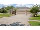 A large driveway leading to the three-car garage of a single-story home with a well-maintained lawn at 3009 Sheehan Dr, Land O Lakes, FL 34638