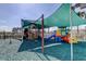 Community playground featuring covered play structures, swings, and a soft landing surface for safety at 3009 Sheehan Dr, Land O Lakes, FL 34638