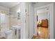 Bright bathroom with a pedestal sink and classic fixtures, adjacent to a bedroom with hardwood floors at 3120 8Th N Ave, St Petersburg, FL 33713