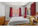 The bedroom features hardwood floors, lots of natural light, white walls, and bright red curtains at 3120 8Th N Ave, St Petersburg, FL 33713
