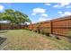 Backyard featuring a patio, landscaping, a privacy fence, and a large tree at 4209 Stratfield Dr, New Port Richey, FL 34652