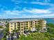 Aerial view showcasing the building's balconies, waterfront access, lush landscaping, and parking at 425 150Th Ave # 2501, Madeira Beach, FL 33708