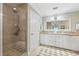Bright bathroom with a glass shower, tiled floor, and double vanity with granite countertop at 425 150Th Ave # 2501, Madeira Beach, FL 33708