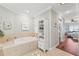 Bright bathroom featuring a soaking tub, linen closet and doorway to the primary bedroom at 425 150Th Ave # 2501, Madeira Beach, FL 33708