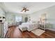 Bright bedroom with wooden floors, a cozy rug, a ceiling fan, and serene views from the window at 425 150Th Ave # 2501, Madeira Beach, FL 33708