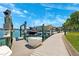 Community boat dock featuring multiple boat and jet ski lifts, concrete walkway, and water access at 425 150Th Ave # 2501, Madeira Beach, FL 33708