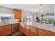 Open kitchen with wood cabinets, granite countertops, and scenic water views beyond the dining area at 425 150Th Ave # 2501, Madeira Beach, FL 33708