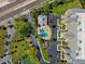 Aerial of the community pool showing surrounding landscaping, pool house, and nearby parking at 425 150Th Ave # 2501, Madeira Beach, FL 33708