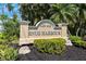 Elegant community sign for Snug Harbour with lush greenery and beautiful landscaping at 425 150Th Ave # 2501, Madeira Beach, FL 33708