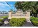 Community sign for Snug Harbour with well-maintained landscaping and clear street signage at 425 150Th Ave # 2501, Madeira Beach, FL 33708