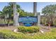 Community sign for Village of Paradise Island featuring lush landscaping and clear blue skies at 472 Sandy Hook Rd, Treasure Island, FL 33706