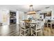 Bright dining area with a wooden table, six chairs, a decorative chandelier, and a built-in bar area at 472 Sandy Hook Rd, Treasure Island, FL 33706