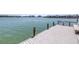 Waterfront wooden dock featuring benches and ample space for relaxing by the water at 472 Sandy Hook Rd, Treasure Island, FL 33706