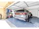 View of a well-organized garage with epoxy flooring and a modern SUV parked inside at 472 Sandy Hook Rd, Treasure Island, FL 33706