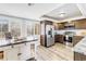 Bright kitchen featuring an island, stainless steel appliances, and wood floors at 472 Sandy Hook Rd, Treasure Island, FL 33706