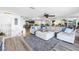 Open-concept living room with hardwood floors and ample seating with kitchen and dining area in background at 472 Sandy Hook Rd, Treasure Island, FL 33706