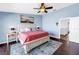 Spacious bedroom with blue walls, wood floors, ceiling fan, and ensuite bath entrance at 472 Sandy Hook Rd, Treasure Island, FL 33706