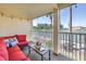 Relaxing patio with a comfortable red cushioned couch and a view of a tennis court and water at 472 Sandy Hook Rd, Treasure Island, FL 33706