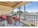 Inviting covered patio with a table, cushioned chairs, and a view of a tennis court and water at 472 Sandy Hook Rd, Treasure Island, FL 33706